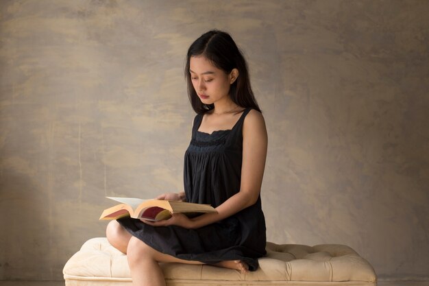 Bella donna asiatica che legge un libro