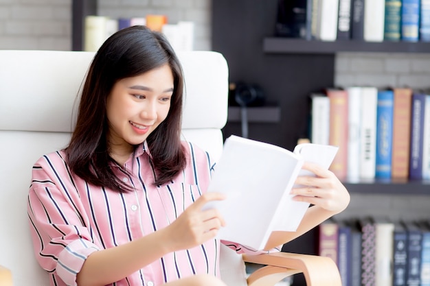 La bella donna asiatica si distende il libro di lettura di seduta