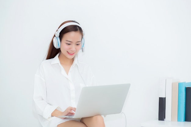 아름 다운 아시아 여자 착용 헤드폰 휴식 노트북을 사용 하여 듣는 음악을 즐길 수