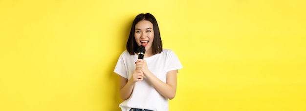 아름 다운 아시아 여자 노래 가라오케 마이크 행복 미소와 카메라 st 보고 수행