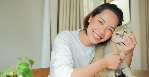 아름다운 아시아 여자 미소와 매력적인 사랑스러운 고양이 키우기