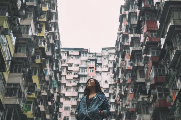 A beautiful asian woman standing among the crowded residential building of the community in Quarry Bay, Hong Kong