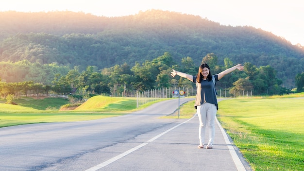 美しいアジアの女性は、道路に立って