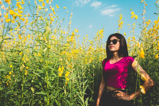 Красивая женщина Азии, стоя в поле sunhemp в сельской местности