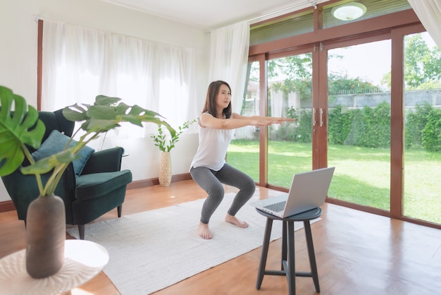 Beautiful asian woman staying fit by exercising at home for healthy trend lifestyle