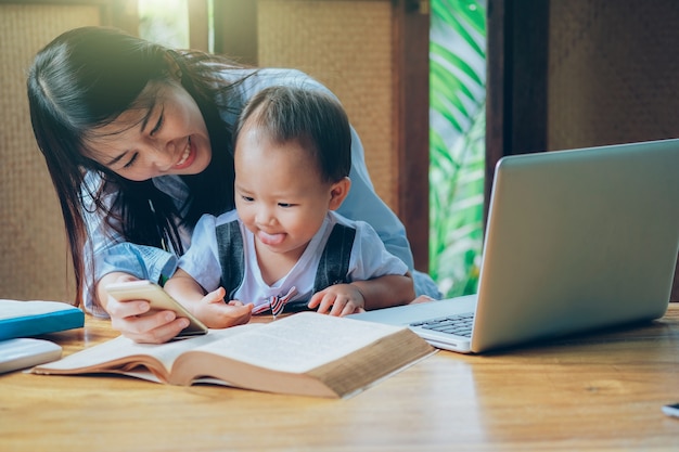 Beautiful Asian woman teaching a lesson to her son 