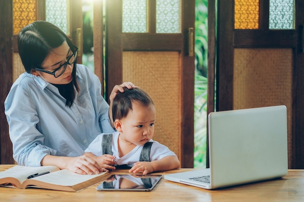 Beautiful Asian woman teaching a lesson to her son 