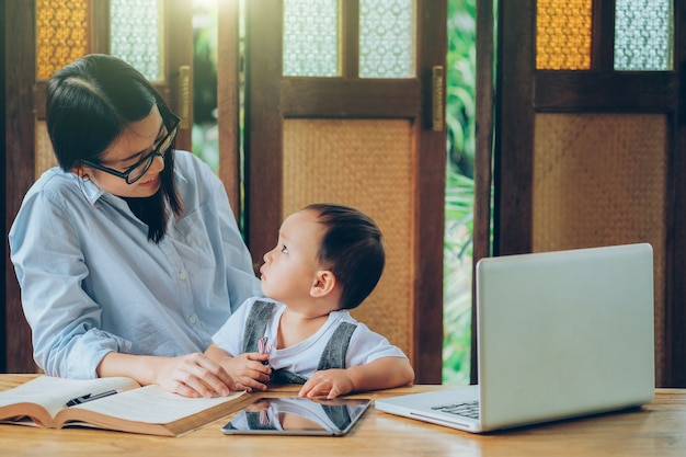 Beautiful Asian woman teaching a lesson to her son 