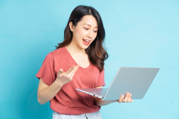 Beautiful Asian woman using laptop to video call with friends