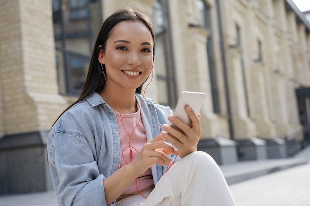 Beautiful asian woman using mobile phone outdoors