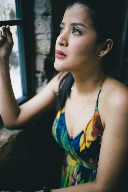 Photo beautiful asian woman waiting and posing for the camera in a lovely dress