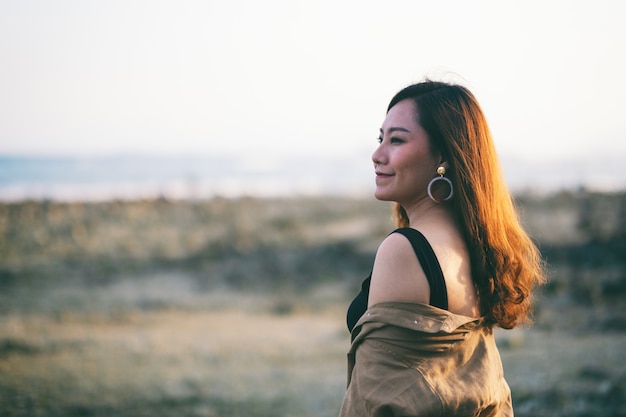 A beautiful asian woman walking on the beach by the seashore