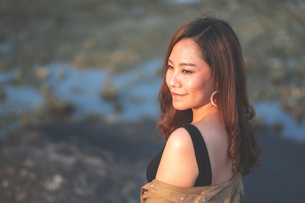 A beautiful asian woman walking on the beach by the seashore