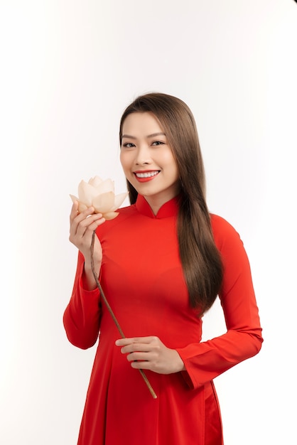 Beautiful Asian woman wearing Ao dai Vietnam and holding flower. Isolated on white.