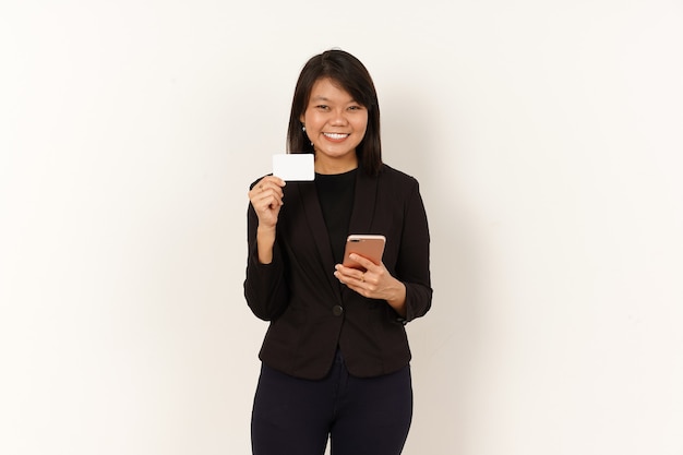 검은 양복을 입은 아름다운 아시아 여성 빈 신용 카드를 들고 스마트폰을 들고