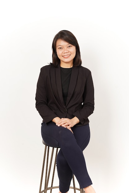 Beautiful Asian Woman Wearing black suit sit and looking at camera Isolated on white background