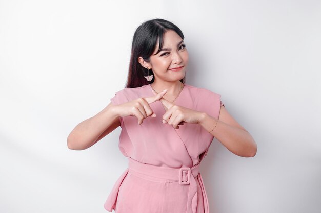 Beautiful Asian woman wearing pink blouse with hand gesture pose rejection or prohibition with copy space