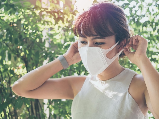 Beautiful asian woman wearing white protective N95 mask