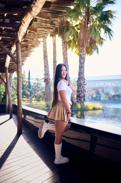 Photo beautiful asian woman in white tshirt and shorts posing on the pier