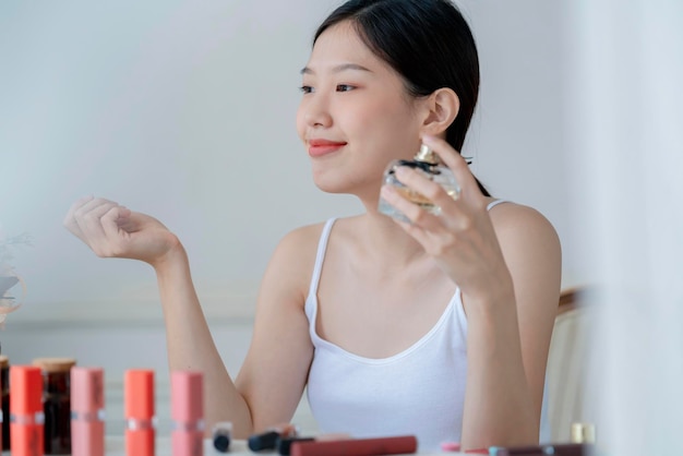 Beautiful asian woman white tshirt smile with happiness hand hold blush on and makeup cosmetic items in bedroom with healthy face skincare concept