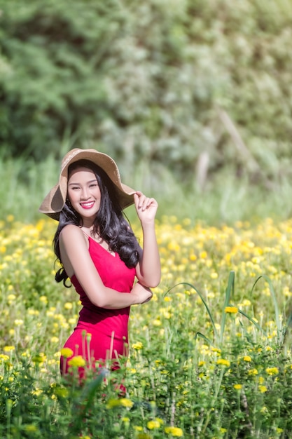 Beautiful asian woman with red dress in  Marigold flower field