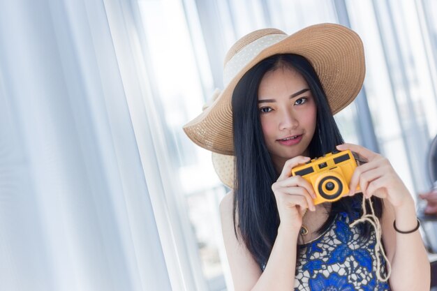 beautiful Asian Woman with yellow camera with happiness 