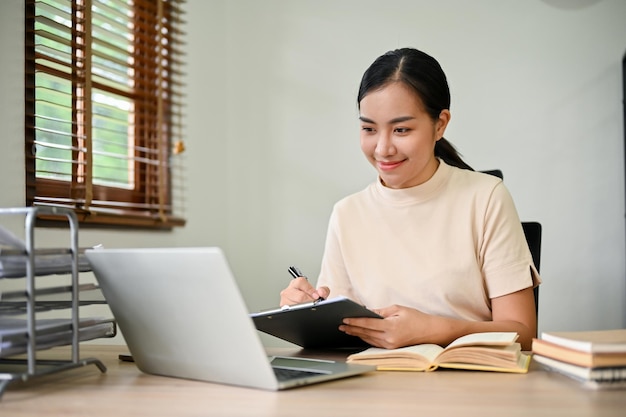 Beautiful Asian woman working with digital tablet in her desk