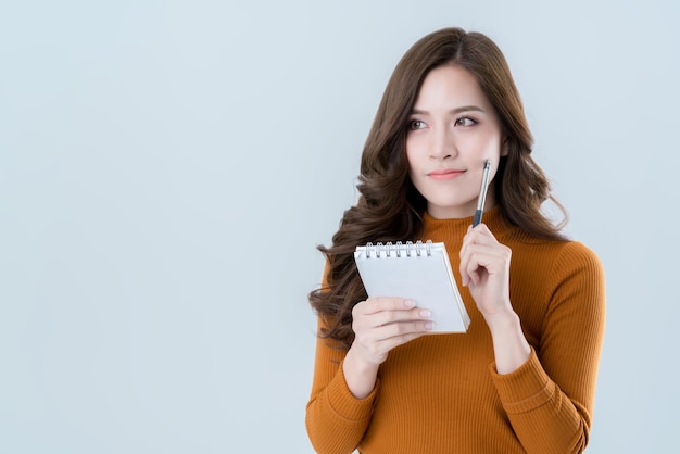 Beautiful asian woman write down note in paper with happiness and joyful moment isolate white background