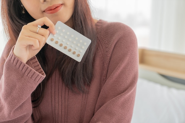 beautiful Asian women holding Birth control pill