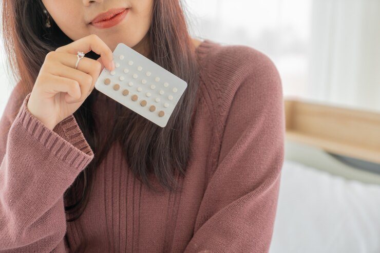 Photo 経口避妊薬を保持している美しいアジアの女性