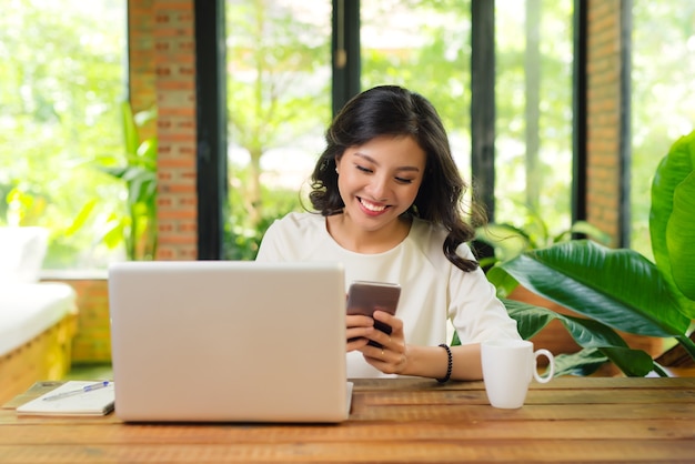 beautiful asian womon holding a credit card and purchasing online