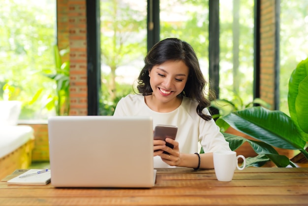 Beautiful asian womon holding a credit card and purchasing online