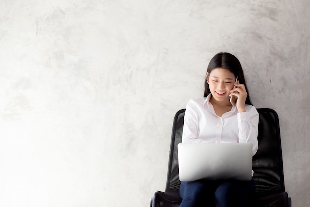 Beautiful asian young businesswoman excited and glad of success with laptop.