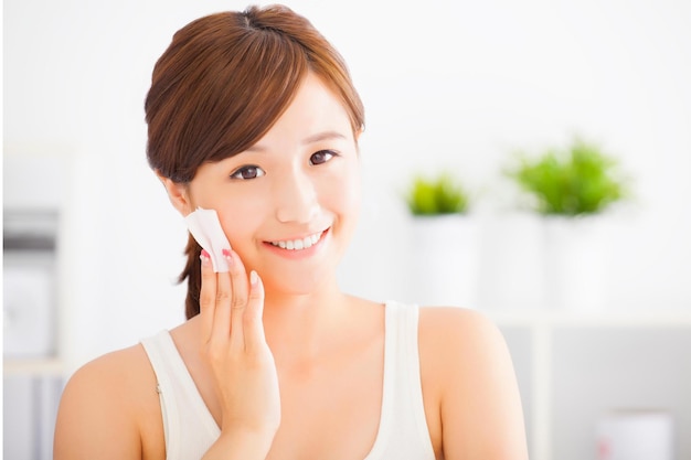 Photo beautiful asian young woman cleaning her face with cotton