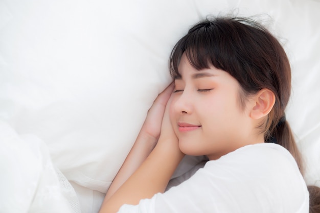 ベッドで横になっている眠っている美しいアジアの若い女性