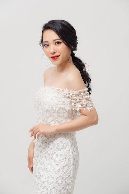 Beautiful Asian young woman in white dress posing on the white background