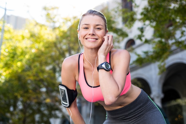 A beautiful athlete putting her headphones 