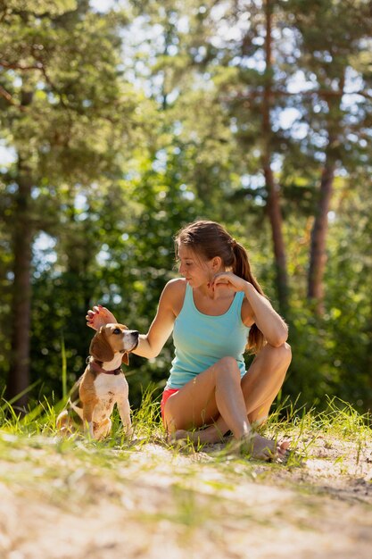 A beautiful and athletic European girl does sports in nature with her dog fitness and yoga