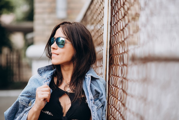 Beautiful athletic girl in black clothes and glasses on the playground. Healthy lifestyle. 