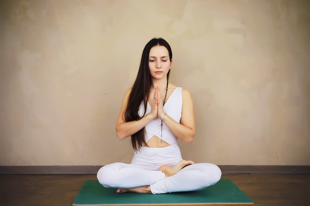 La bella ragazza atletica che fa gli esercizi di yoga gode della meditazione a casa. nessuno stress, sana abitudine, concetto di sollievo dall'ansia. posa del loto.