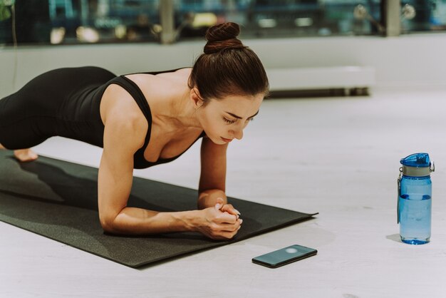 Foto bella donna atletica allenamento in palestra, facendo esercizi di stretching prima dell'allenamento