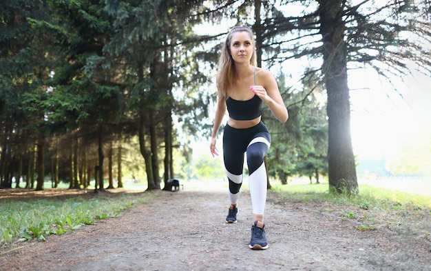 Beautiful athletic young woman starts jogging in park