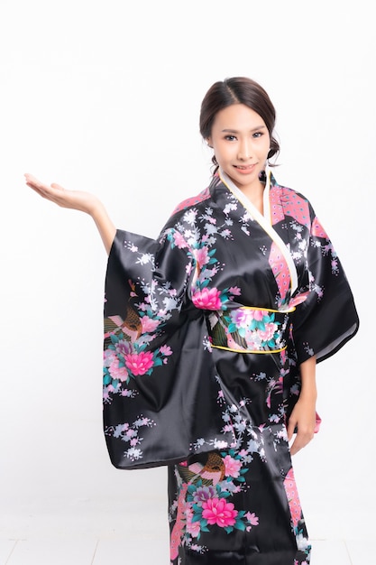 Красивая привлекательная азиатская женщина в традиционном японском кимоно изолирована