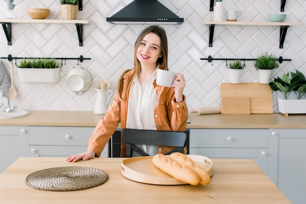 Beautiful attractive female with coffee tea mug in kitchen color , housewife, home, wife, mother