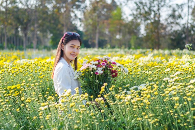 公園でカラフルな花を持つ美しい魅力的な女の子