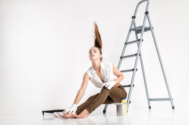 Photo beautiful attractive woman painting a wall in her house