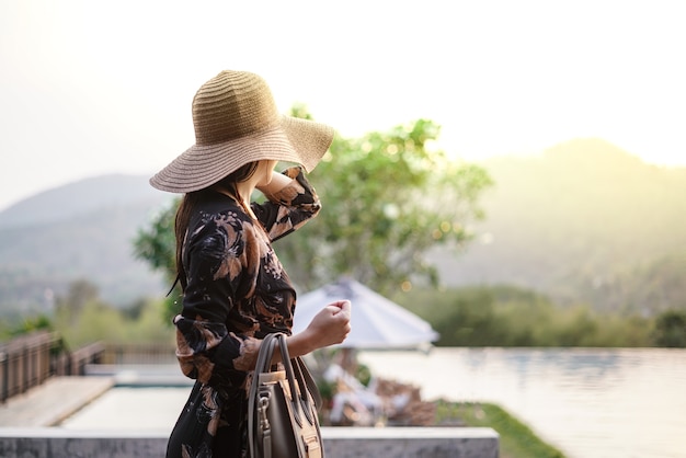 Beautiful attractive woman at the swimming terrace with oversize hat over her eyes