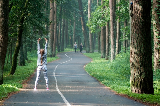 公園でストレッチ美しい魅力的な若い女性