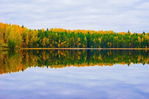 Beautiful autumn landscape with reflection of the autumn forest in the lake