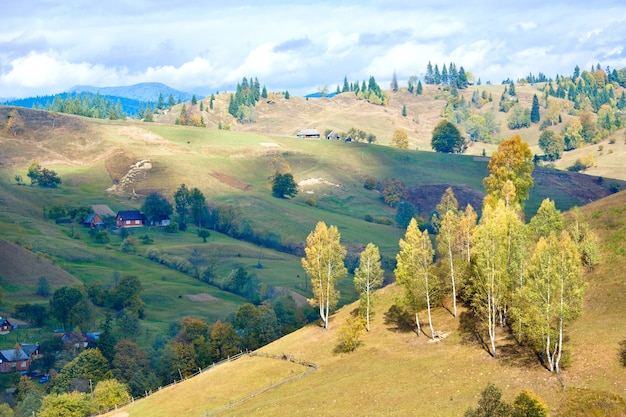 美しい秋の山と山腹の小さな村（カルパティア山脈、ウクライナ）
